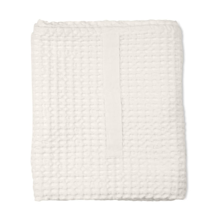 Imagine a big waffle towel and large throw blanket that's large enough to be like an adult snuggle blanket. Remember the mini version you perhaps had as a child? Well, here you have it in organic cotton with a luxurious and tactile waffle weave. The extra large throw and towel is multi-use as an absorbent large bath towel, a cosy sofa throw or large bedspread. And why not bring it along as as a pool towel or picnic blanket? You can choose the Scandinavian colour that best suits your style. Seen here in natural white. Size: 100 x 150 cm Material: 100% GOTS certified organic cotton Weaving: Waffle, grosgrain strap