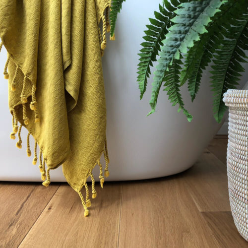 Ela Turkish bath towel in gorse yellow. Jacquard woven from heavy weighted absorbent cotton that's quick to dry. With simple, textured design. Finished with hand twisted and knotted fringe. It takes up 1/3 of the space of a standard towel. 90 x 180cm