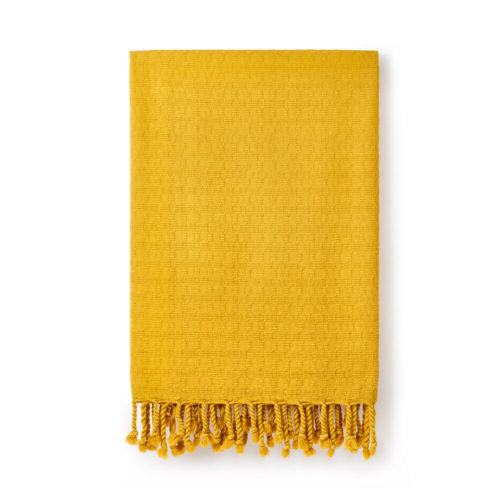 Ela Turkish bath towel in gorse yellow. Jacquard woven from heavy weighted yet quick drying cotton with simple, textured design. Finished with hand twisted and knotted fringe. It takes up 1/3 of the space of a standard towel. 90 x 180cm