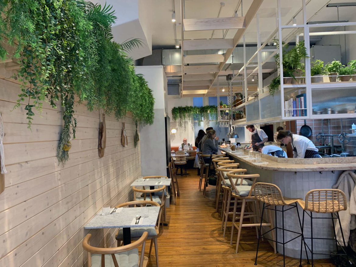 Where to eat in Brighton : I visited Kindling, a new restaurant in Brighton based on zero waste, local produce & healthy eating. Check out this taster menu! The environment is a biophilic design dream. Scandi wood cabin chic, plants a plenty, and the menu calls out to eat natural and eat local. Your eyes are drawn from the beautiful wooden tables and chairs upwards along the plants, hanging like a curtain that continue towards the high ceilings. It's like industrial meets plant filled log cabin, it's just lush. It's a stone's throw from Brighton beach and the shops in the Lanes, so the perfect spot. The all British taster menu we were treated to included UK grown tomatoes, local wasabi, venison and beef from the Knepp estate re-wilding project (and via the gun shop across the road!), and of course lots of wild garlic. Yes, the wild garlic season is here! (if you're after a foraging bag, check this best seller out). Beef is also sourced from Herstmonceux and Ditchling, while lamb comes from Saddlescomb Farm, all in the Sussex area.