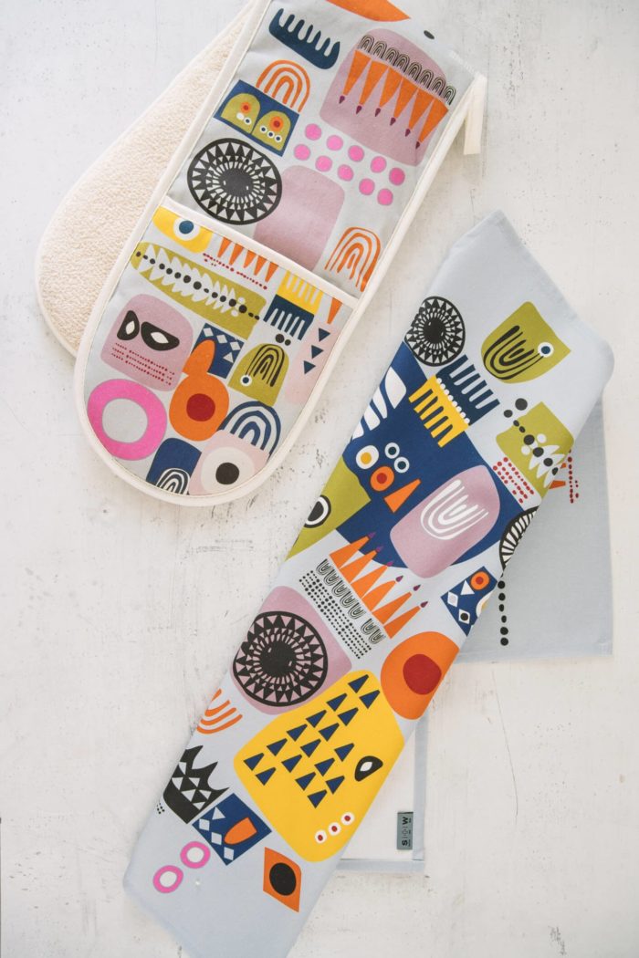 The "Shapes" colourful oven gloves and matching tea towel in an abstract, bold and contemporary design. This is the Shapes 1, in a yellow tone, featuring bright and colourful combinations of abstract patterns resembling faces. (Design 2 has a blue dominance). You can mix and match the Shapes colourful oven gloves with tea towels in the same design. You can see the whole Softer + Wild collection here. 85 x 20 cm 100% European cotton with towelling back Heat resistant Hanging loop Wash at 40 degrees Made in Great Britain Softer + Wild dyes are gentle and water based, giving a rustic, organic feel to their products – perfect for presents and giving you comfort, luxe and design to the table and your interior. The fabrics are robust, with a beautiful design that you can keep for many years. The more you use it, the more it softens and relaxes, decorating your home in vibrant colours.