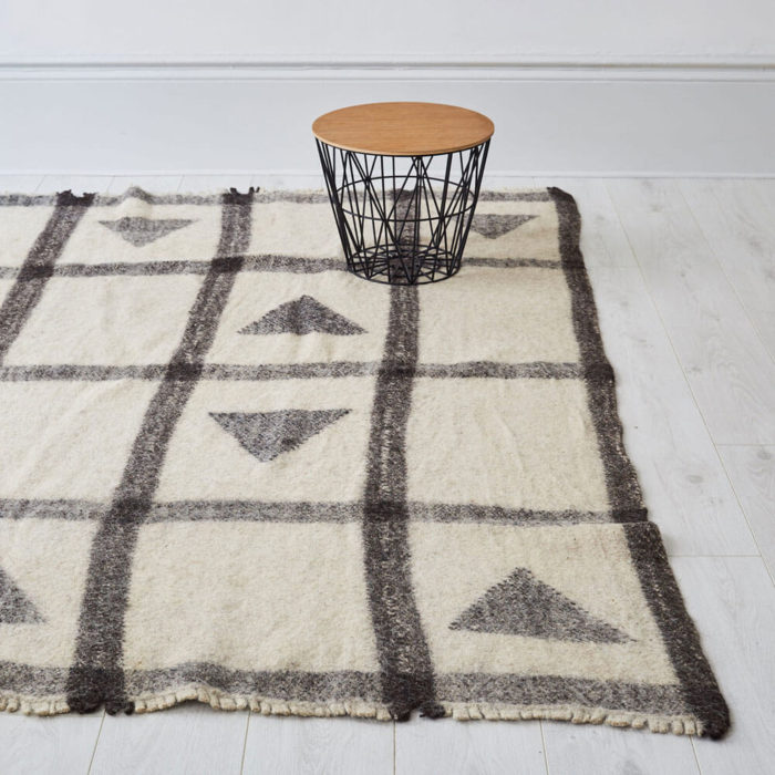 Nuptse Radhi Himalayan sheeps wool rug. Hand woven in Nepal on traditional back-strap looms. Using un-dyed local sheep’s wool, these boiled sheeps wool rugs are then washed in hot water to felt the wool. The result is a thick, hard wearing and washable monochrome rug in grey and white, perfect for a neutral, natural home. Anti-slip underlay also available in pre-cut sizes. Simply trim to fit on installation. Large 175 x 225cm [88” x 69”] Washable Pure Himalayan Wool Handwoven, felted These sheeps wool rugs are made by Radhi Weavers. Based on traditional radhi produced for the local market in Nepal, these best selling rugs are often used as blankets, floor coverings and even worn to keep out the cold and rain. They're woven in the Himalayas by artisans using wool from local sheep, which is hand-spun. Stitch & Stitch use only the un-dyed wool in their fair trade rug designs - creamy white and a dark grey wool from black sheep. The radhi are first woven on simple back-strap looms, which can be set up anywhere - against a tree or a building. The looms are narrow, and the cloth woven on them is only about 36cm wide. To create a larger piece such as a carpet, several strips of cloth are sewn together by hand.