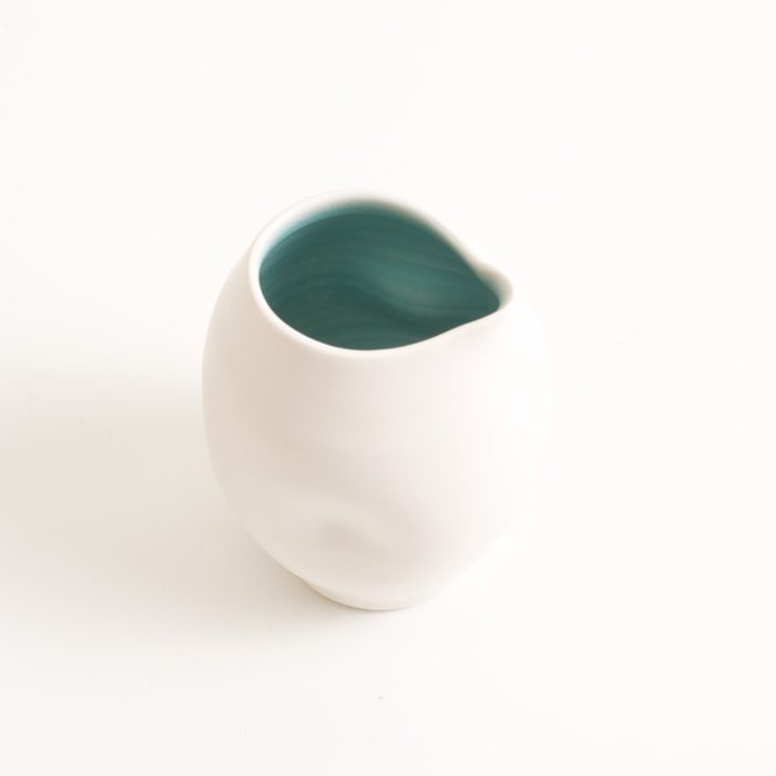 Handmade porcelain dimpled jug turquoise. With a matt white glaze on the outside and soft coloured inside. Available in white, grey and turquoise, in two sizes. Perfectly formed dimples to fit in your hand. Handmade by Linda Bloomfield in London. Sold on chalkandmoss.com.