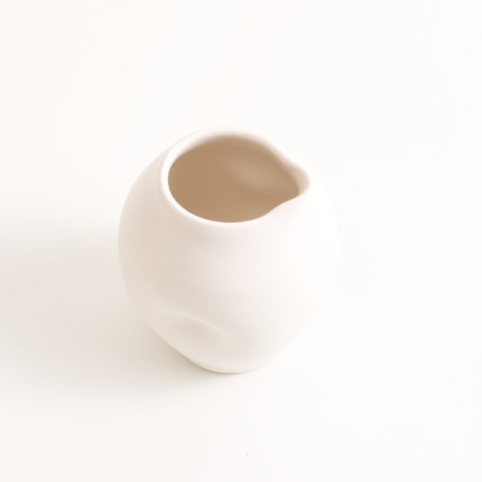 Handmade porcelain dimpled jug medium white. With a matt white glaze on the outside and soft coloured inside. Available in white, grey and turquoise, in two sizes. Perfectly formed dimples to fit in your hand. Handmade by Linda Bloomfield in London. Sold on chalkandmoss.com.