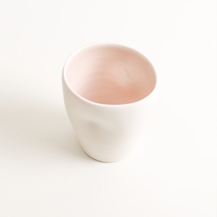 Handmade Dimpled Cup Pink inside. With a matt white glaze on the outside and soft coloured inside. Available in pale blue, pale pink, grey and turquoise. Perfectly formed dimples to fit your hand, where the shape is inspired by Japanese tea traditions. Sold on chalkandmoss.com.