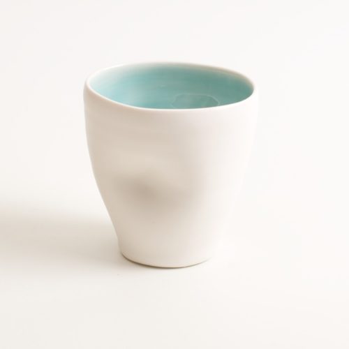 Handmade Dimpled Cup turquoise. With a matt white glaze on the outside and soft coloured inside. Available in pale blue, pale pink, grey and turquoise. Perfectly formed dimples to fit in your hand, where the shape is inspired by Japanese tea traditions. Handmade by Linda Bloomfield in London. Sold on chalkandmoss.com.