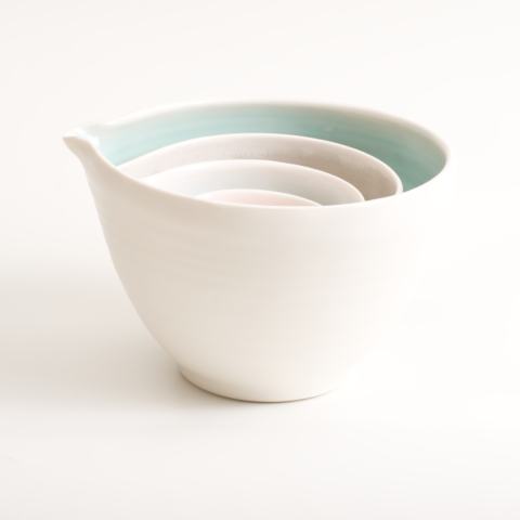 Handmade nesting porcelain pouring pottery bowls by Linda Bloomfield. Set of four. Featuring tactile dimples instead of handles. Inside glazed in pale blue, turquoise, pink or grey. Available as a set of three or four.