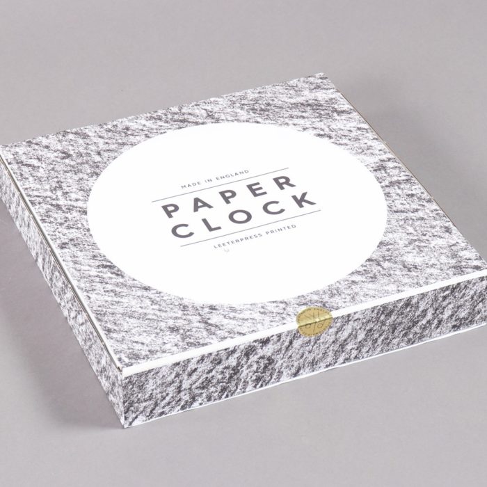 Paper clock, shown in its packaging. The clock is made from recycled paper with a sturdy back. By Wald, on Chalk & Moss (chalkandmoss.com).
