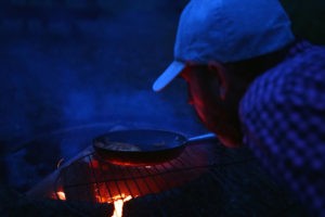 Cooking chanterelles and porcini mushrooms over a open fire, while wild camping in Southern Sweden.