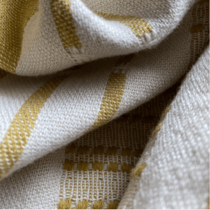 Defne are super soft and sumptuous, jacquard loomed peshtemals in organic cotton, perfect for cooler seasons. 90 x 175 cm. Seen here in close up of the pickle colour.