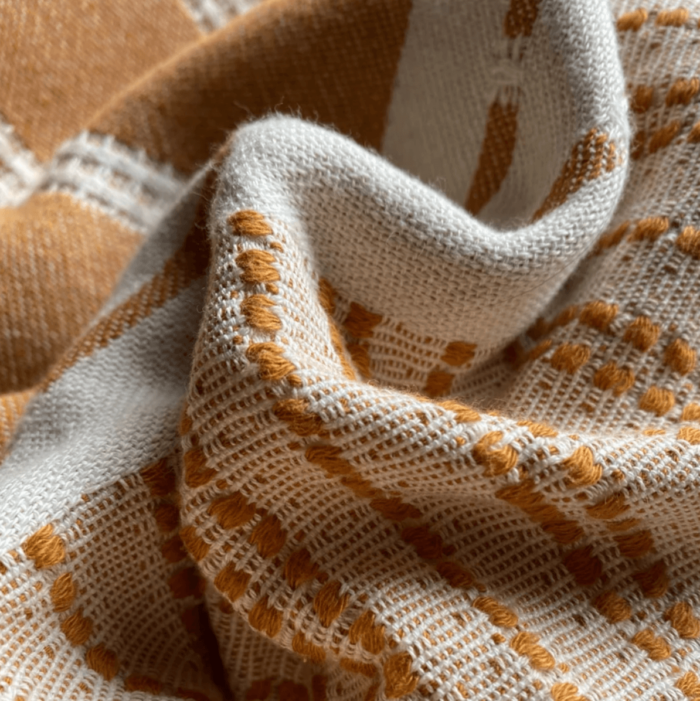 Defne are super soft and sumptuous, jacquard loomed peshtemals in organic cotton, perfect for cooler seasons. 90 x 175 cm. Seen here in close up of the tan colour.